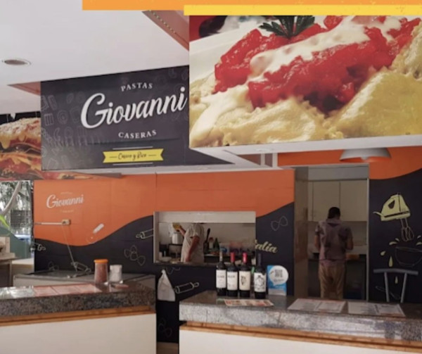 Local de comidas caseras con mostrador y cocina visible, especializado en pastas italianas.