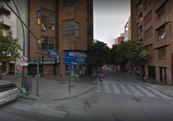 Calle con edificios altos, árboles y tienda 