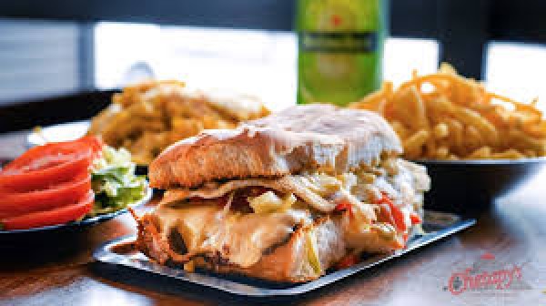 Sandwich de pollo con queso derretido, acompañado de papas fritas y ensalada, en Lomitos Chetapy's.