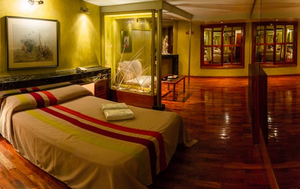 Habitación acogedora del Hotel Ruta con cama grande, suelos de madera y decoración moderna. Ambiente elegante y confortable.