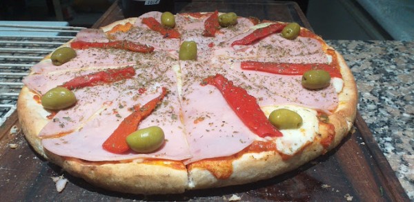 Pizza 23: Deliciosa pizza con jamón, aceitunas verdes y pimientos rojos sobre masa crujiente. Ideal para compartir.
