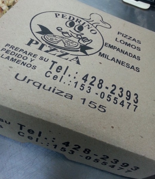 Caja de Pedrino Pizzas con logo y detalles de contacto. Ofrece pizzas, empanadas y milanesas. Ubicación: Urquiza 155.