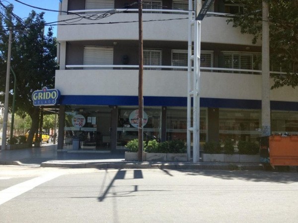 Edificio comercial con fachada blanca y azul, letrero 