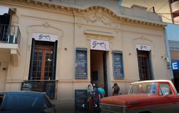 Edificio antiguo con fachada beige y detalles ornamentales. Entrada de 