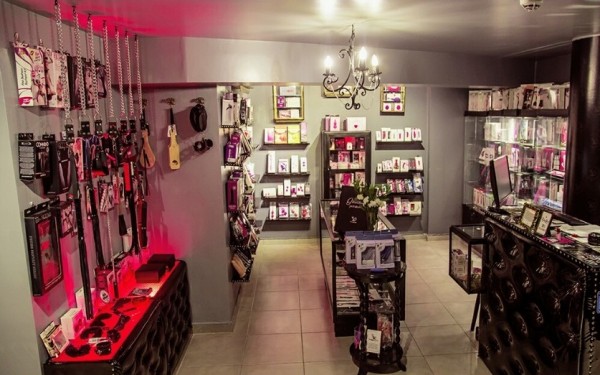 Tienda Flora Multiespacio con estanterías llenas de productos, luces rojas y decoración elegante.