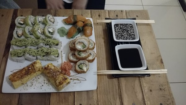 Plato de sushi variado en Sushibox: rollos, nigiri y tempura acompañados de wasabi, jengibre y salsa soya.