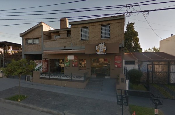 Edificio de dos pisos con fachada de ladrillo y letrero 