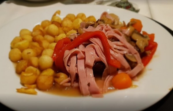Plato de Viejo Lobo: carne con jamón, champiñones, pimientos y patatas fritas, presentado en plato blanco.