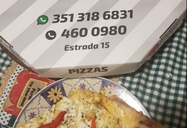 Pizza en plato decorado junto a caja blanca con números y texto 