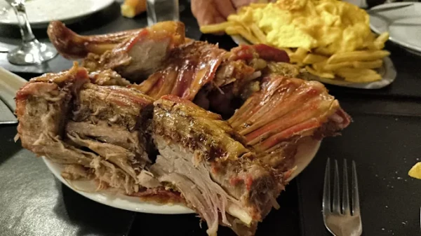 Plato de carne asada con papas fritas en un restaurante informal.