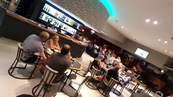 Gente disfrutando comidas y bebidas en el animado Punto Urca, con iluminación moderna y ambiente acogedor.