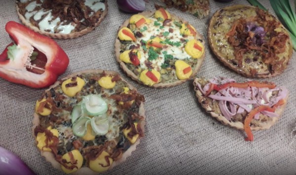 Mini pizzas variadas con vegetales y carnes en 'Señora Tarta', sobre tela rústica. Decoración colorida y apetitosa.