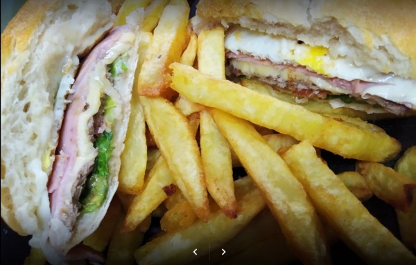 Sandwiches rellenos con jamón y huevo, acompañados de papas fritas doradas. Pedrino Pizzas. Delicioso y apetitoso.