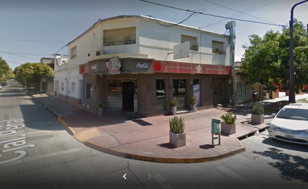 Edificio blanco con fachada roja y negra, letrero 