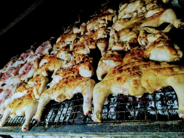 Pollos asados dorados y jugosos dispuestos en parrilla, listos para ser servidos. Aroma irresistible.