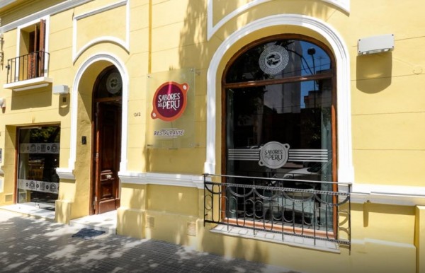 Edificio amarillo con ventana grande y puerta marrón. Señal 