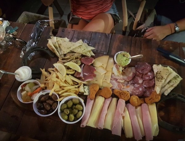 Mesa con tabla de quesos, embutidos, frutas y aceitunas en 