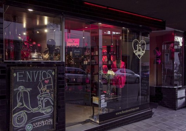 Vitrina iluminada de Flora Multiespacio con maniquíes y productos. Cartel negro con moto y texto 