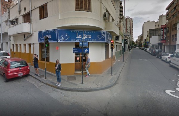 Esquina urbana con edificio amarillo y azul. Restaurante 