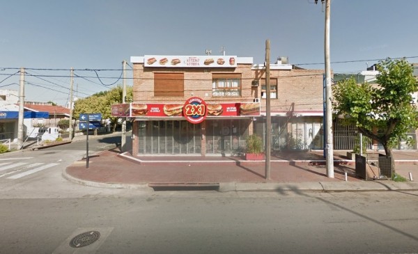 Edificio comercial con fachada roja y letrero 