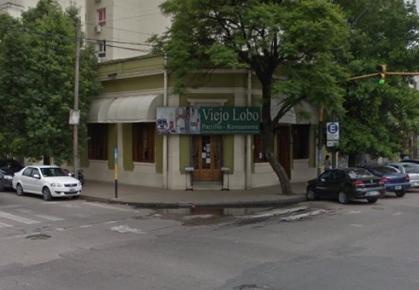 Edificio blanco con detalles verdes, cartel 