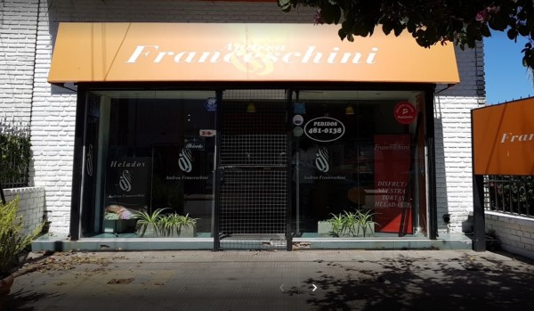 Fachada de Andrea Franceschini, heladería con letrero naranja y vidrios transparentes, plantas en entrada, día soleado.